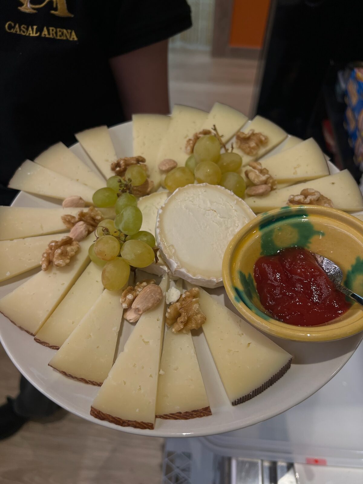 Tabla de quesos con uvas, nueces y mermelada